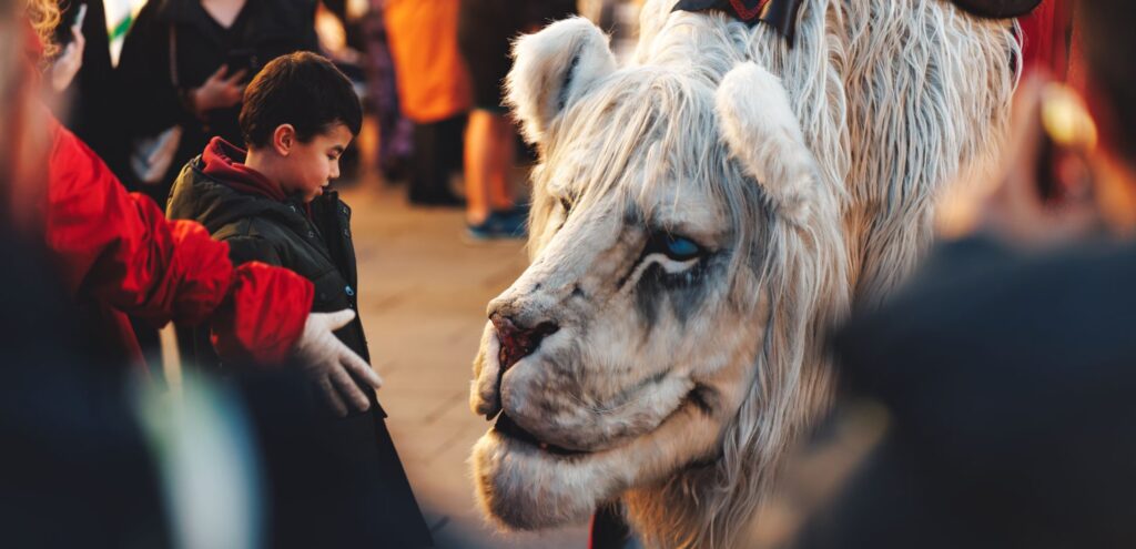 Child interacting with white snow lion puppet apart of Southampton's Countdown to Christmas event